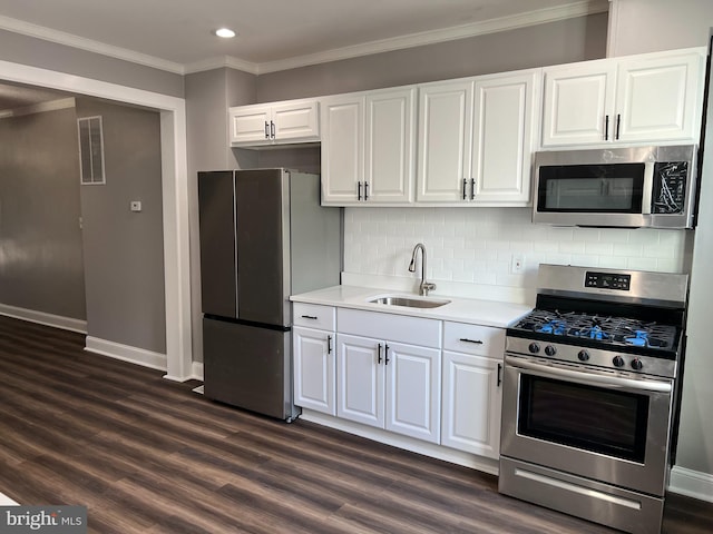 kitchen featuring stainless steel appliances, sink, dark hardwood / wood-style flooring, white cabinetry, and tasteful backsplash