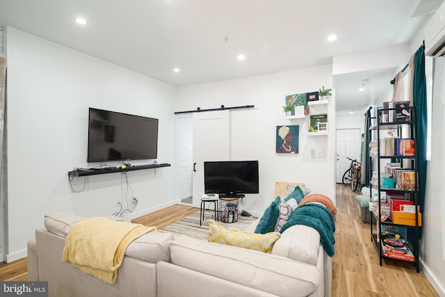 living area featuring wood finished floors, recessed lighting, and a barn door