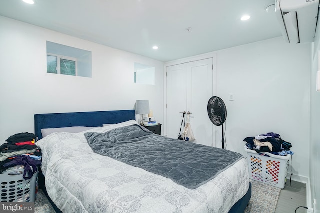bedroom with a closet, wood finished floors, and recessed lighting