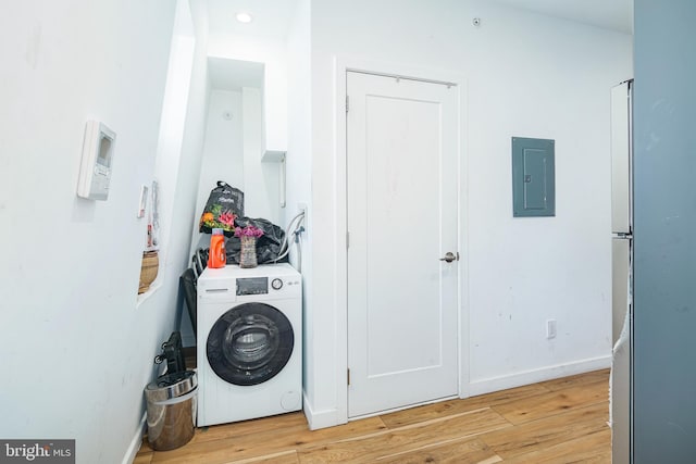washroom featuring electric panel, baseboards, light wood-style floors, laundry area, and washer / dryer