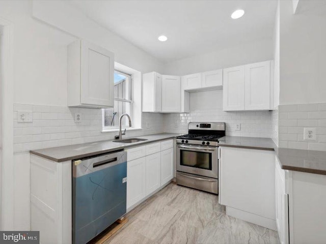 kitchen featuring appliances with stainless steel finishes, white cabinets, and sink