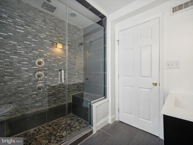 bathroom with a shower with door and vanity