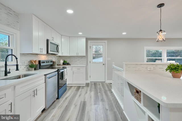 kitchen with white cabinets, stainless steel appliances, sink, and plenty of natural light