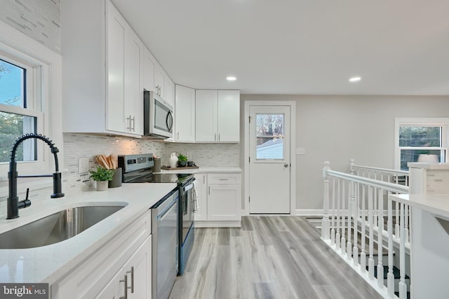 kitchen featuring white cabinets, stainless steel appliances, sink, and plenty of natural light