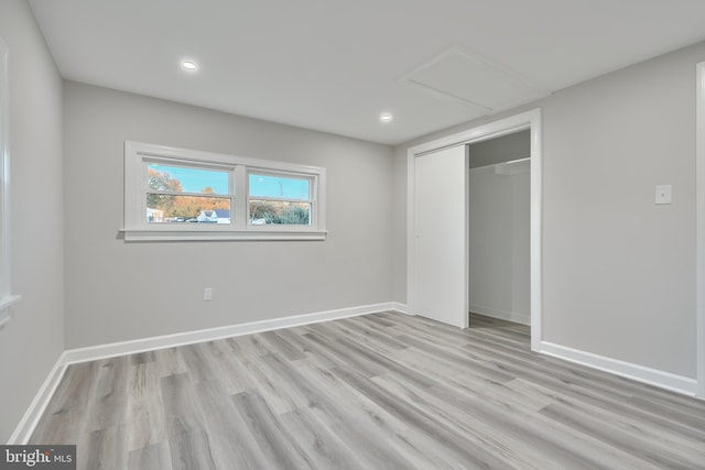 unfurnished bedroom featuring a closet and light wood-type flooring