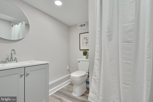 bathroom with vanity, hardwood / wood-style floors, and toilet