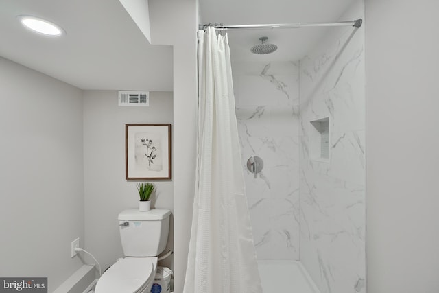 bathroom with curtained shower and toilet