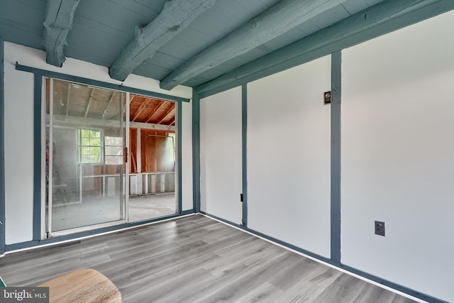 unfurnished room featuring beam ceiling, wooden ceiling, and light wood-type flooring