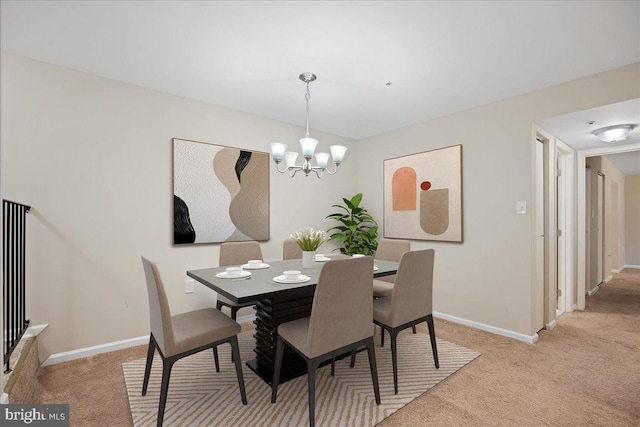 dining area with an inviting chandelier and light colored carpet