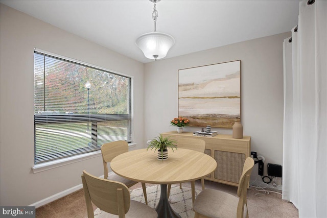 dining room featuring light colored carpet and a healthy amount of sunlight