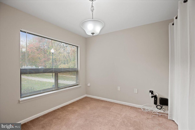 unfurnished room featuring light colored carpet and a healthy amount of sunlight