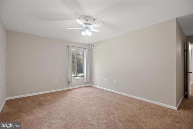 carpeted spare room with ceiling fan