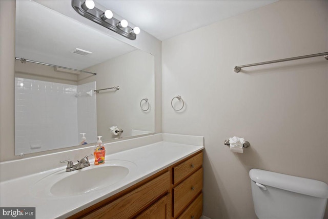 bathroom with a shower, vanity, and toilet