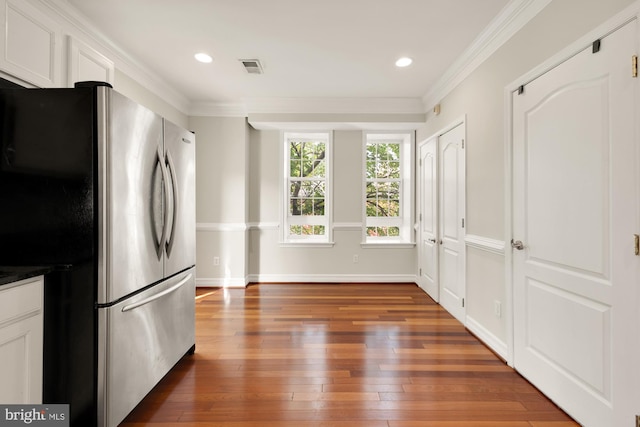 kitchen featuring ornamental molding, stainless steel fridge, white cabinets, and dark hardwood / wood-style flooring