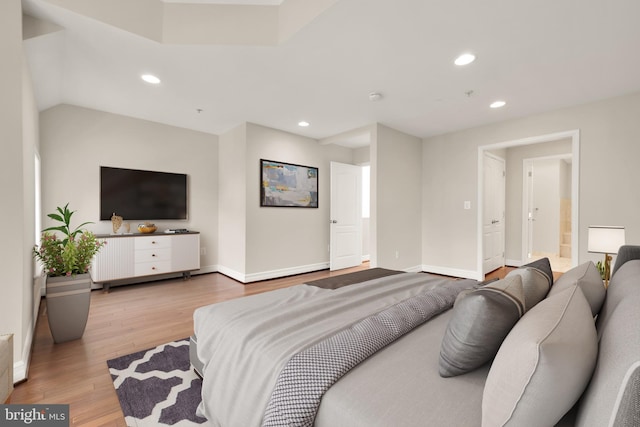 bedroom with ensuite bathroom and light hardwood / wood-style floors