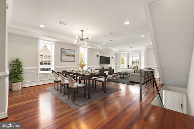 dining room featuring crown molding, a notable chandelier, and dark hardwood / wood-style flooring