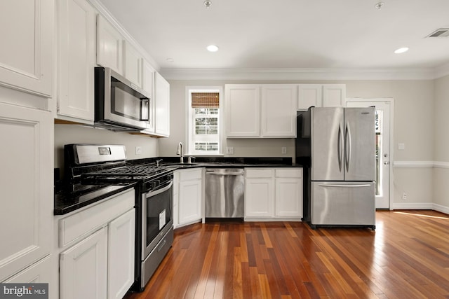 kitchen featuring dark hardwood / wood-style floors, sink, crown molding, white cabinets, and appliances with stainless steel finishes