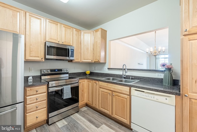 kitchen featuring sink, hanging light fixtures, stainless steel appliances, a chandelier, and light hardwood / wood-style floors