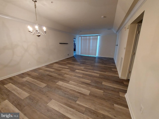 spare room with a chandelier and hardwood / wood-style floors