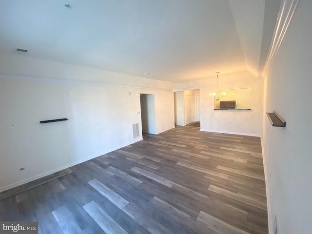 unfurnished living room featuring dark hardwood / wood-style floors and an inviting chandelier