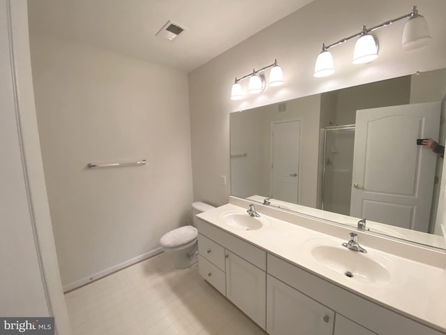 bathroom with vanity, toilet, and a shower with door