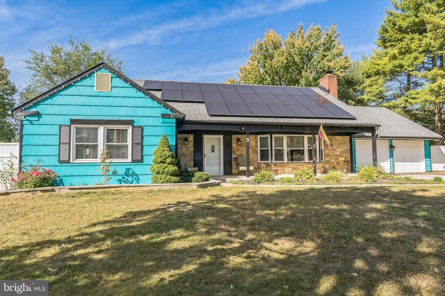 view of front of house with a garage, a front lawn, and solar panels