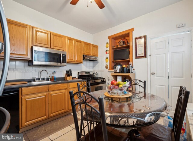 1337 S 54th St, Philadelphia, PA 19143 - kitchen featuring dark countertops, under cabinet range hood, ceiling fan, stainless steel appliances, and a sink