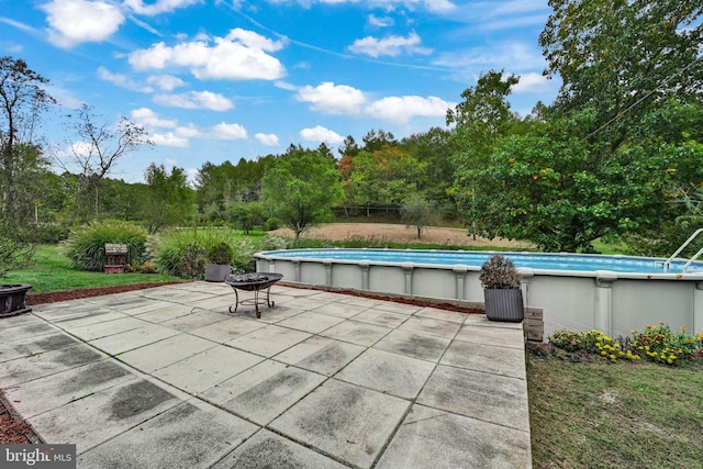 view of swimming pool with an outdoor fire pit and a patio area