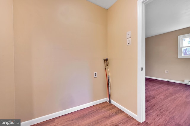 clothes washing area with wood-type flooring