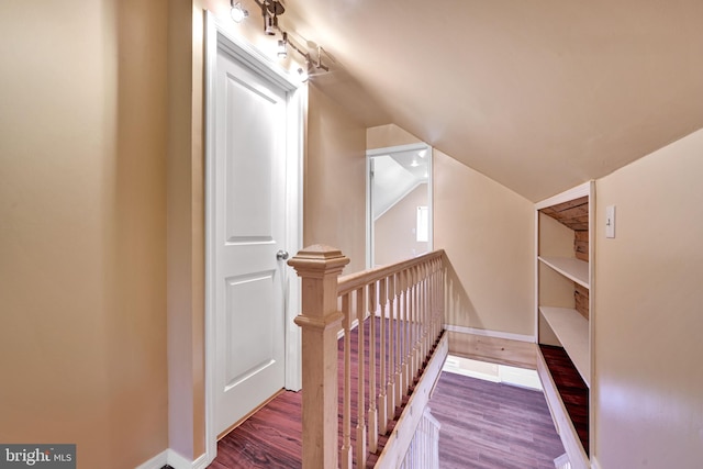 stairway featuring hardwood / wood-style floors and vaulted ceiling