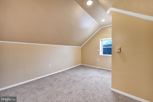 additional living space with carpet flooring and vaulted ceiling