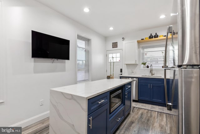 kitchen featuring blue cabinetry, white cabinetry, a center island, and appliances with stainless steel finishes