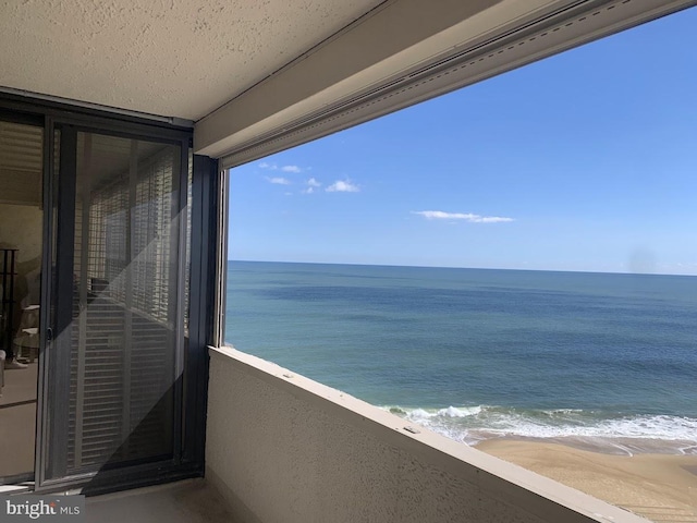 balcony with a water view and a beach view