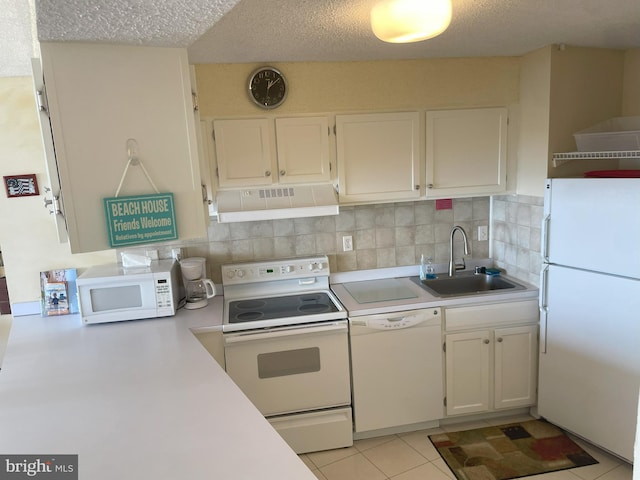 kitchen featuring white appliances, sink, white cabinetry, decorative backsplash, and light tile patterned floors