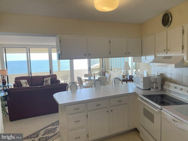 kitchen with kitchen peninsula, white cabinetry, a water view, and white appliances