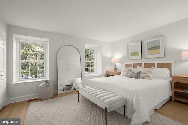 bedroom featuring light hardwood / wood-style flooring and multiple windows