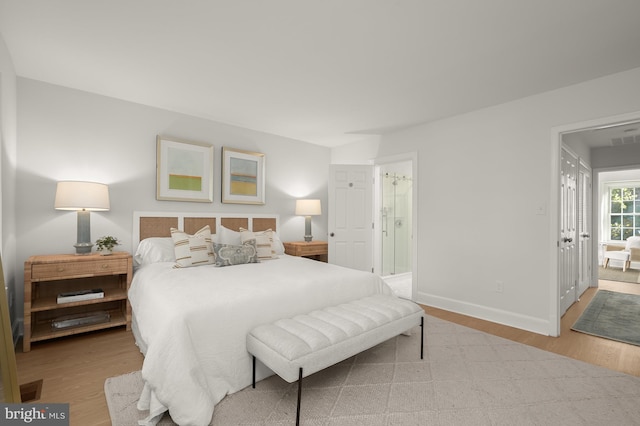 bedroom featuring light hardwood / wood-style floors and ensuite bath