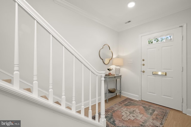 entryway featuring ornamental molding and hardwood / wood-style floors