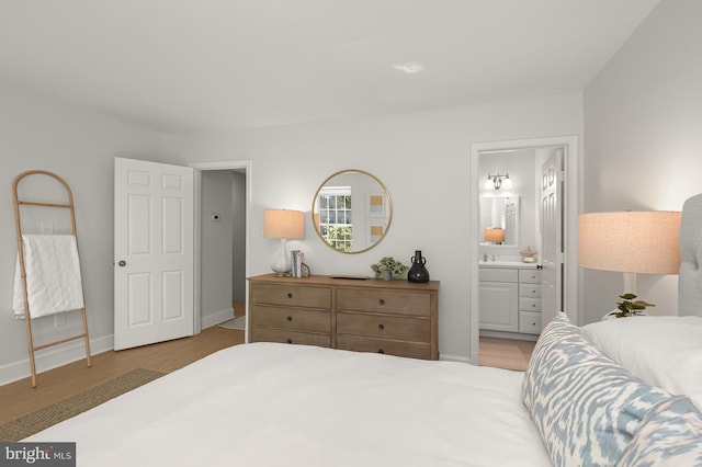 bedroom with light hardwood / wood-style flooring and ensuite bath