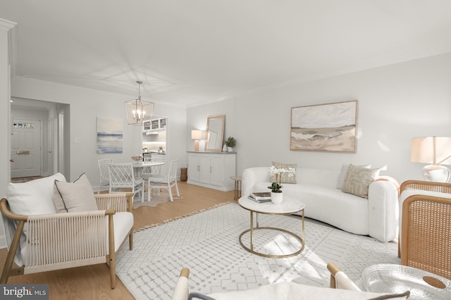 living room with a notable chandelier, crown molding, and light hardwood / wood-style floors