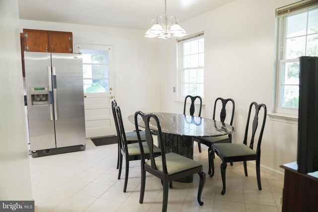 tiled dining room with an inviting chandelier and a healthy amount of sunlight