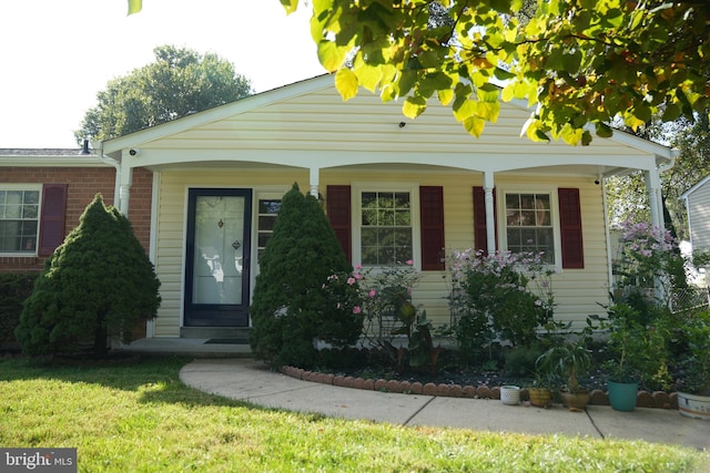 view of front of house with a front yard and covered porch