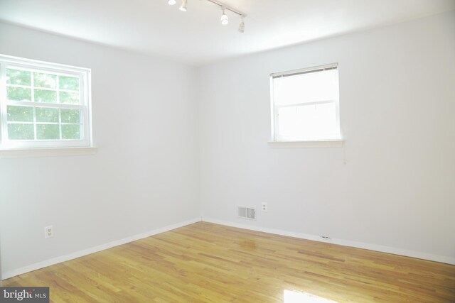 empty room featuring light hardwood / wood-style flooring and rail lighting