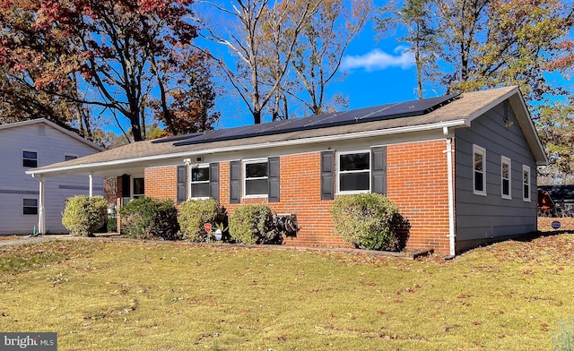 single story home with solar panels and a front lawn