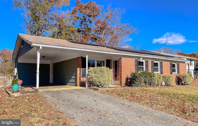 single story home featuring solar panels, a carport, and a front lawn