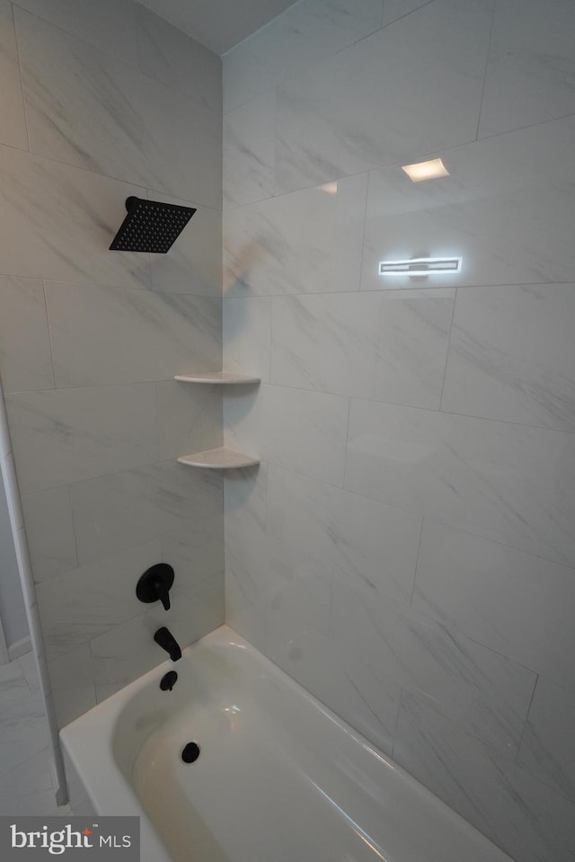 bathroom featuring tiled shower / bath