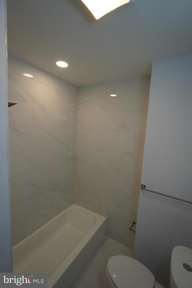 bathroom featuring a tub to relax in and toilet