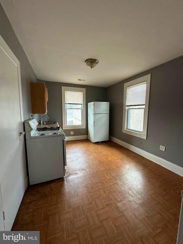 washroom featuring washer / dryer, sink, light parquet flooring, and cabinets