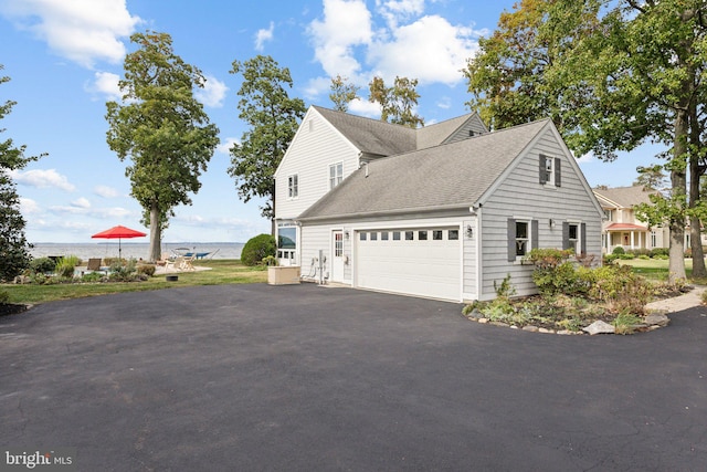 view of side of home featuring a water view and a garage