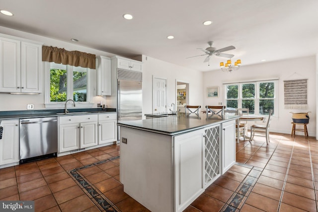 kitchen featuring stainless steel appliances, plenty of natural light, and white cabinets